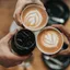 Overhead view of coffee cups with latte art on a warm table